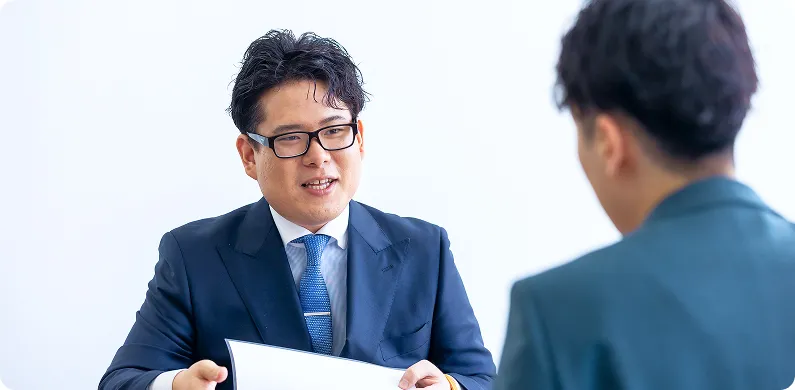 社内で笑顔で打ち合わせする様子