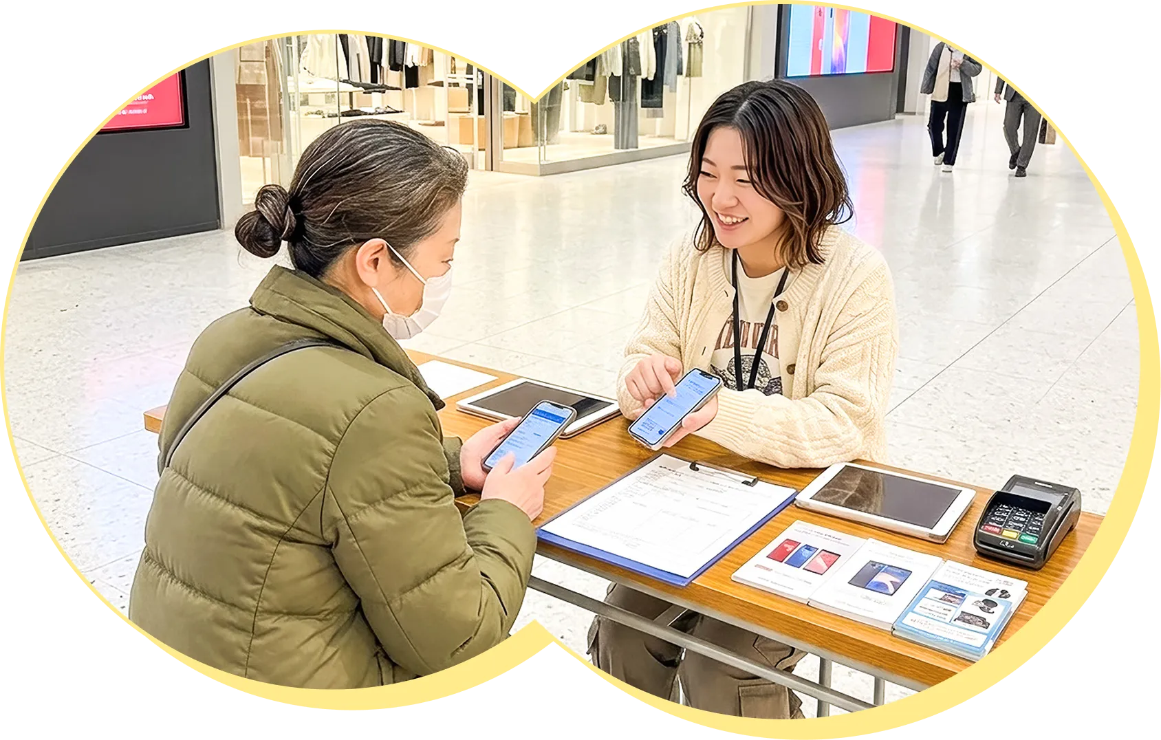 商業施設にてお客様に携帯プランの説明をするソニックの女性スタッフ
