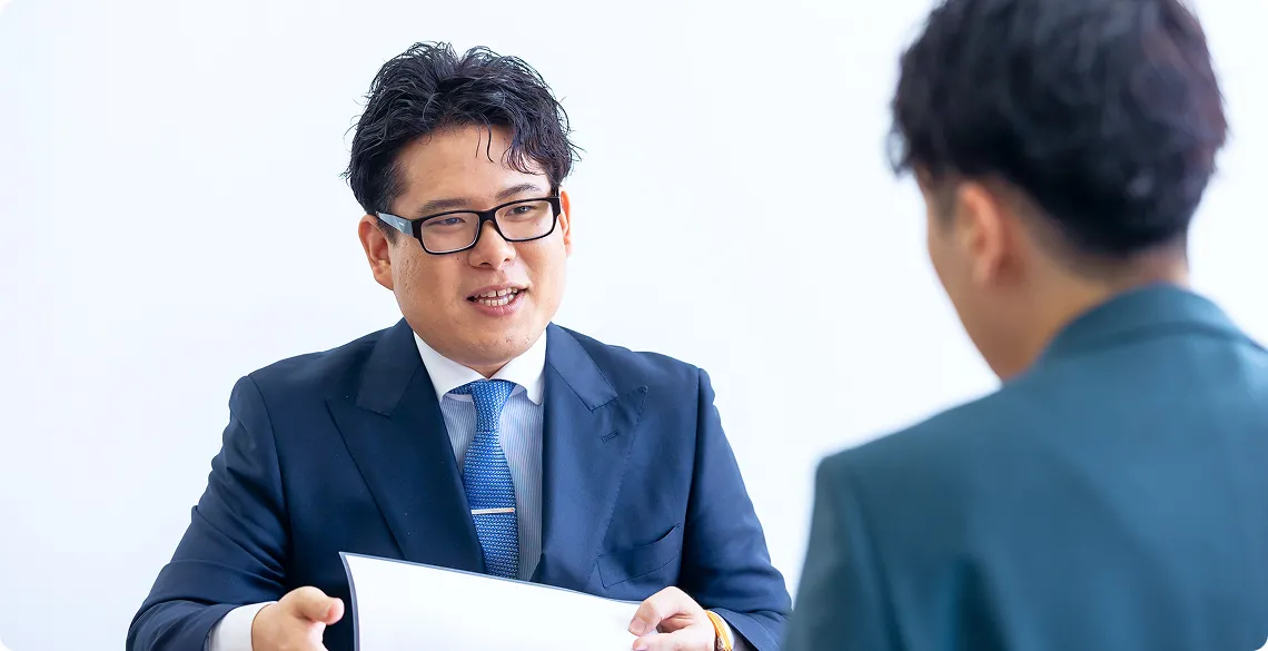 社内で笑顔で打ち合わせをする様子